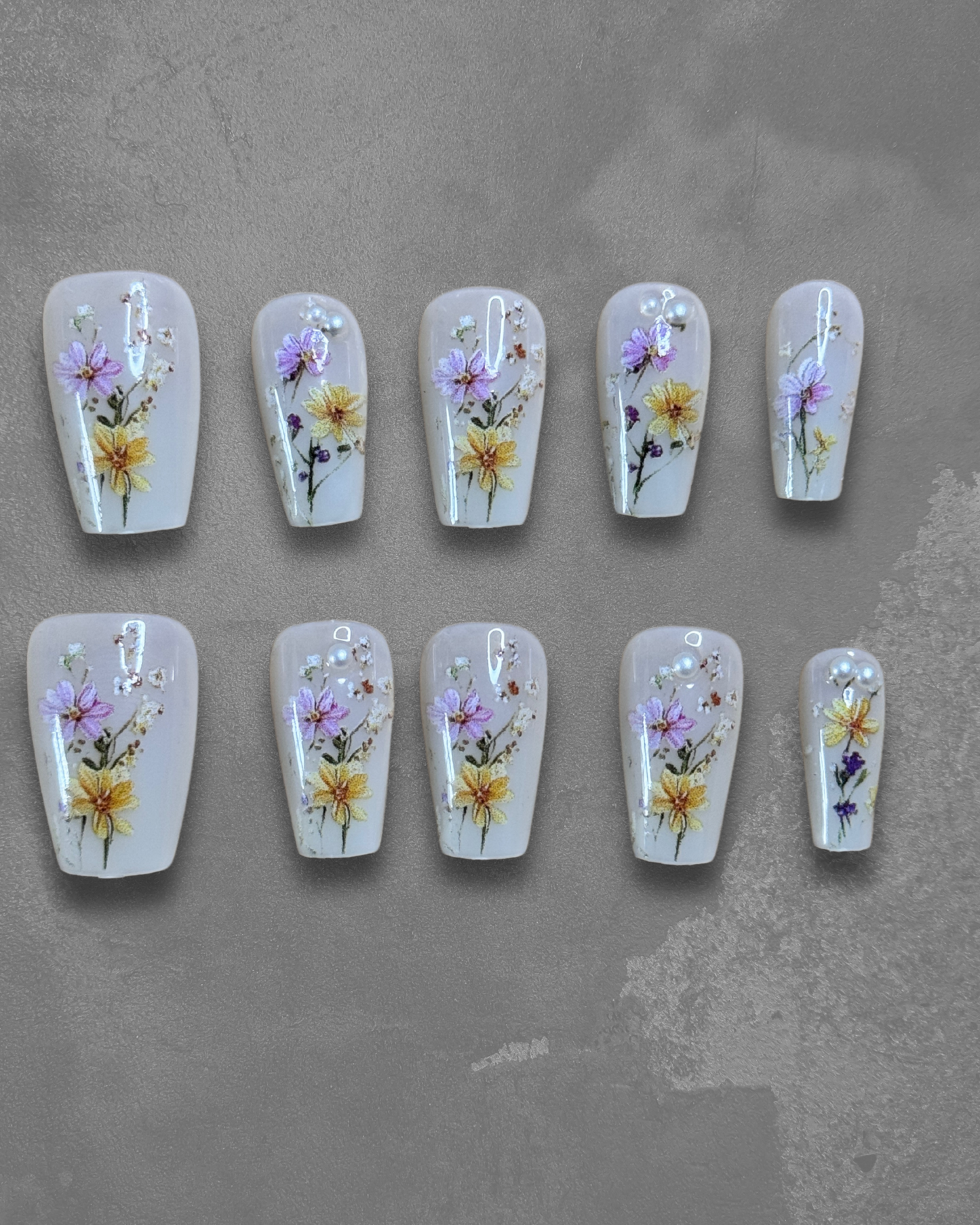 front view Botanic Dust press on nails with hand-painted yellow and purple florals on neutral base, square shape